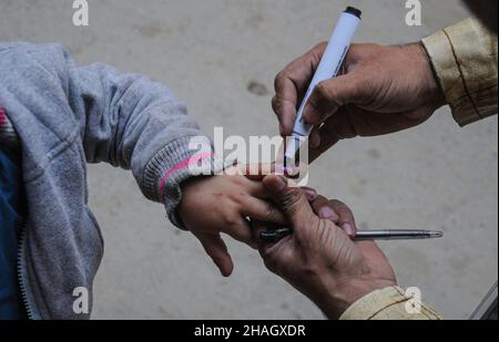 RAWALPINDI, Pakistan - December 13: A health worker administers polio vaccine to a child during an anti-polio drive in Rawalpindi on December 13, 2021 Stock Photo