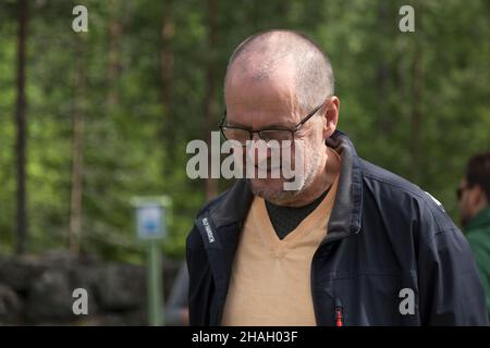 Umea, Norrland Sweden - July 16, 2019: elderly man with glasses looking at something on the ground Stock Photo