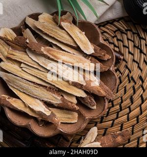 Top view of Chinese traditional herbal medicine Astragalus root on wooden table background. Stock Photo