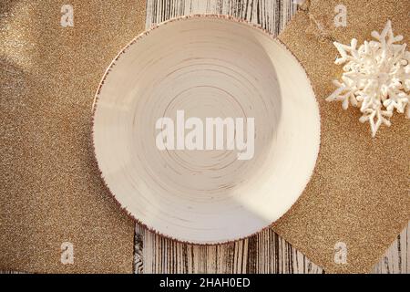Festive Christmas table serving mock up. Vintage beige plate with Christmas decorations on the table. Trendy Christmas tree toys and shadows. Top view Stock Photo