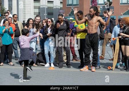 A young lad upstages a professional busker dancer to the delight of the audience. In Union Square Park, lower manhattan, new York City. Stock Photo