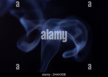 Abstract white smoke moves on black background. Beautiful swirling gray smoke. Stock Photo