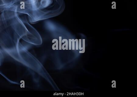 Abstract white smoke moves on black background. Beautiful swirling gray smoke. Stock Photo