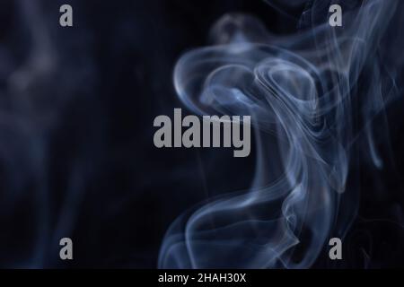 Abstract white smoke moves on black background. Beautiful swirling gray smoke. Stock Photo