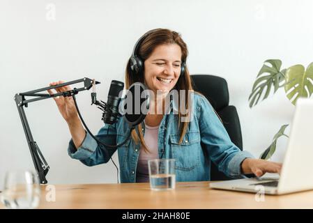 Woman using laptop and recording podcast Stock Photo