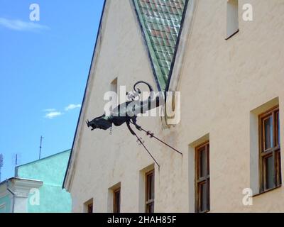 A decorative iron figure of a mythical chimera is installed on the facade of an old house Stock Photo