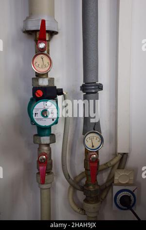 Various gas boiler pressure gauges with iron pipes emanating from them and pressure switches Stock Photo