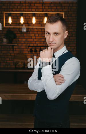 Morning of the groom. Groom morning preparation. Young and handsome groom getting dressed in a wedding shirt Stock Photo