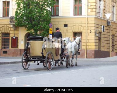 Equestrian vintage open carriage in the historical part of the city with two horses and a coachman Stock Photo