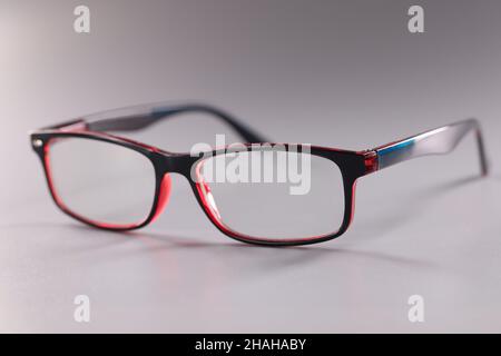 Fashionable plastic glasses red-black on gray background Stock Photo