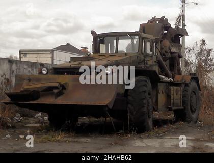 Military engineering earthmoving machine on wheels with trenching bucket, old and rusty Stock Photo