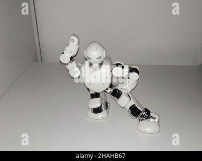 Dancing white little humanoid smart robot raised up his hand Stock Photo