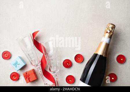 Champagne Valentine's Day, Birthday, Wedding, Anniversary, Women's Day, 8 March. Champagne bottle and two empty glasses, gift boxes and red candles, r Stock Photo