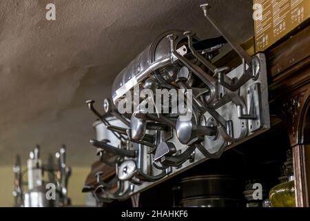 Numerous aluminium ladles and hooks hang tightly packed on a wall rack in Kader Zennaf's private collection in Saint-Chamond, Loire department, France. He started collecting as a child, after being given a small coffee mug made of the French light metal himself. Stock Photo