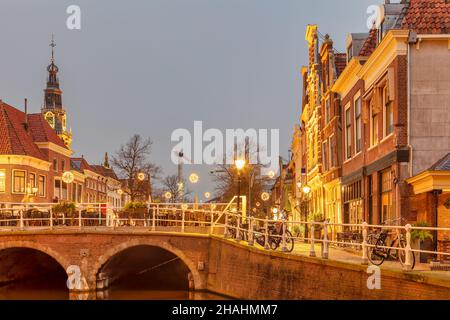 Evening view of an ancient street with christmas decoration in the historic city center of the Dutch city of Alkmaar Stock Photo