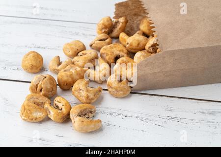 Canjica, hominy or white corn popcorn, sweet popcorn in a bag over wooden table. Stock Photo