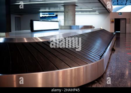 Baggage carousel at the airport. Empty luggage carousel in arrival hall. Airport without passengers due canceled flight. Stock Photo