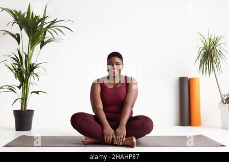 Happy black woman plus size practicing yoga Stock Photo
