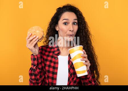 Funny Young Lady Holding Burger And Drink Stock Photo
