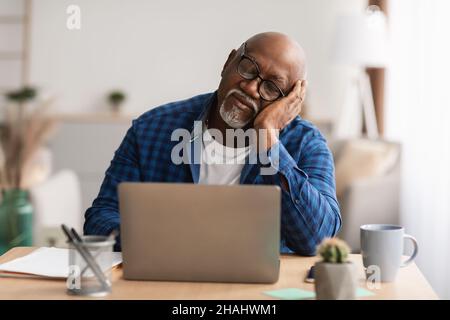 Senior Black Man Sleeping At Laptop At Workplace In Office Stock Photo
