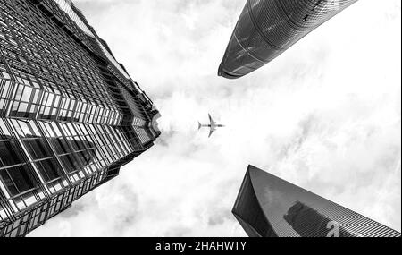 Black and white shot of plan flying over Modern skyscrapers of Shanghai Stock Photo