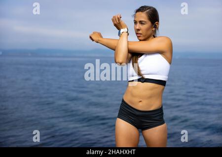 Fit Woman Looking Away While Doing Warm Up Exercise Stock Photo