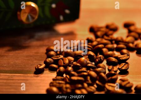 Vintage coffee concept with selective focus on roasted coffee beans and old coffee grinder in the background. Stock Photo