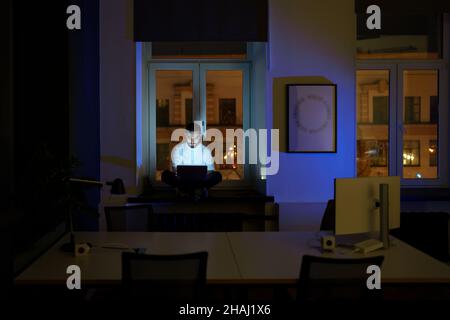 Freelancer programmer work on laptop late at night. Web developer coding overtime before deadline Stock Photo