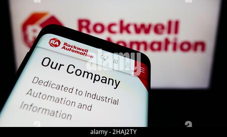 Cellphone with website of American company Rockwell Automation Inc. on screen in front of business logo. Focus on top-left of phone display. Stock Photo