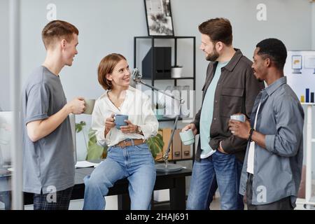 Group of young employees discussing working moments while drinking coffee during coffee break Stock Photo