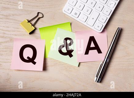 Q concept. Q and A acronym on notes on office desk. QnA. Stock Photo