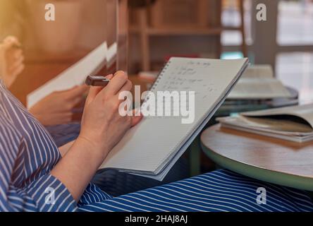 Women hands closeup with pen and planner, planning day, taking notes and writing in notebook. Stock Photo