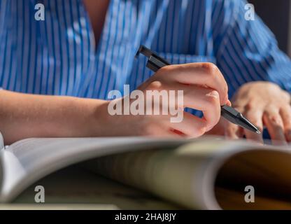 Female hands closeup with pen taking notes, writing in notebook. Stock Photo