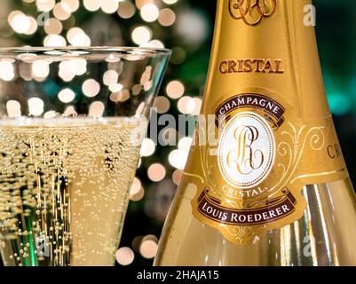 CRISTAL CHAMPAGNE Bottle and freshly poured glass of Louis Roederer Cristal luxury champagne with sparkling party celebration  lights in background Stock Photo