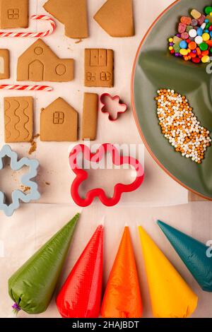 Gingerbread house cookies ready to be decorated with coloured royal icing. Traditional christmas family craft. Stock Photo