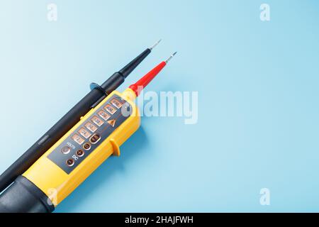 Two-pole voltage indicator close-up on a blue background. Testing and verification of electrical networks Stock Photo