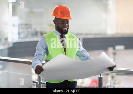 African american guy engineer holding paper drawing template Stock Photo