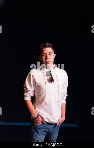 Young Hispanic male posing in front of a black background Stock Photo