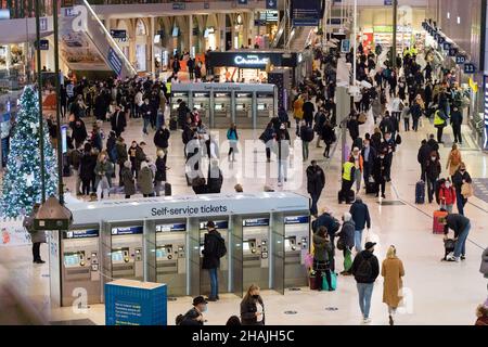 London Waterloo UK 13 December 2021. Commuters checking the departures board for the train home. Those who have to travel to work despite the Plan B covid-19 restriction encouraging people to work from home if possible. Credit: Xiu Bao/Alamy Live News Stock Photo
