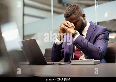 Stressed african american businessman in suit having burnout Stock Photo