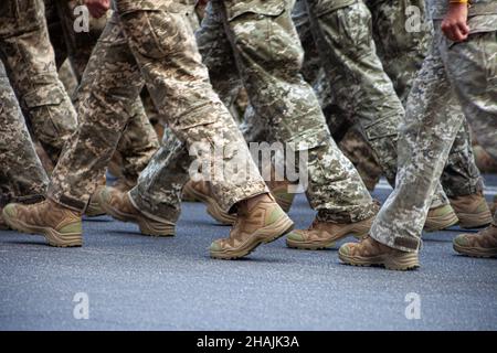 Selective focus. Motion blur. Modern military footwear on soldiers. A soldier in uniform is marching in the parade. People in the crowd. Boots on the foot. Stock Photo