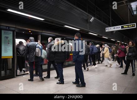 Commuters on the westbound Jubilee Line platform at Canary Wharf Underground station at 16:51 in the evening rush hour, where new restrictions have come into force to slow the spread of the Omicron variant of coronavirus. Picture date: Monday December 13, 2021. Stock Photo