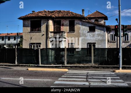 Crossing on a road in the countryside with an abandoned house on the other side of the road Stock Photo