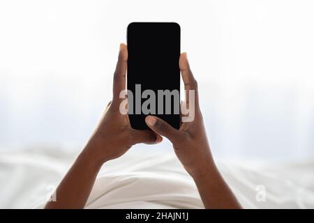 Female hands holding newest cellphone with empty screen Stock Photo