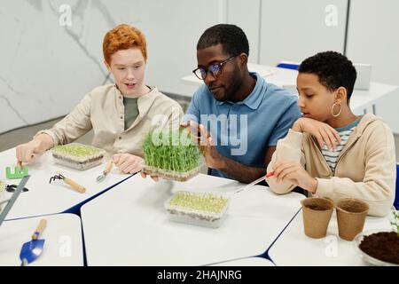 Portrait of African-American teacher working on biology experiments with diverse group of children Stock Photo