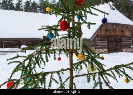 Сhristmas tree decorated with multicolored handmade balls made of yarn. Bright yarn clews of various colors hanging on a fir tree Stock Photo