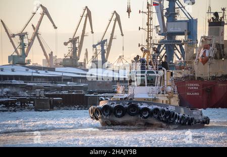 Saint Petersburg, Russia - December 10, 2021: Tugboat in the frozen sea channel. Sea cargo port of St. Petersburg Stock Photo