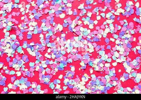 Confetti festive background. Colorful bright paper circles on pink. Decoration for carnival and birthday celebration party. Stock Photo