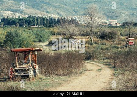 Old abandoned horse carriages left on the side of the country road Stock Photo