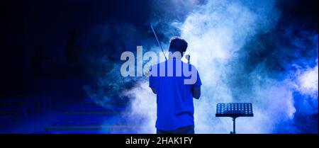 View from the back of a man playing the violin on stage Stock Photo